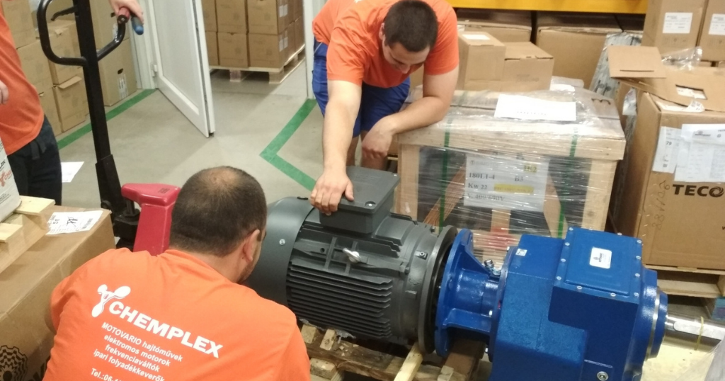Chemplex Szerviz szakemberek ipari villanymotort szerelnek hajtóműre raktári körülmények között